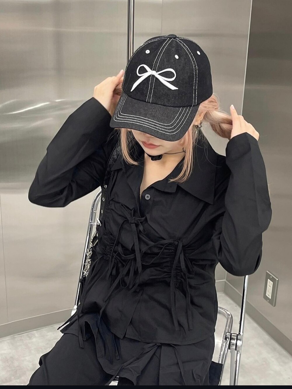 ブラック系のシャツ/ブラウス、ブラック系のショルダーバッグ、ブラック系のキャップを着用したレディースの夏コーディネートの2枚目の写真