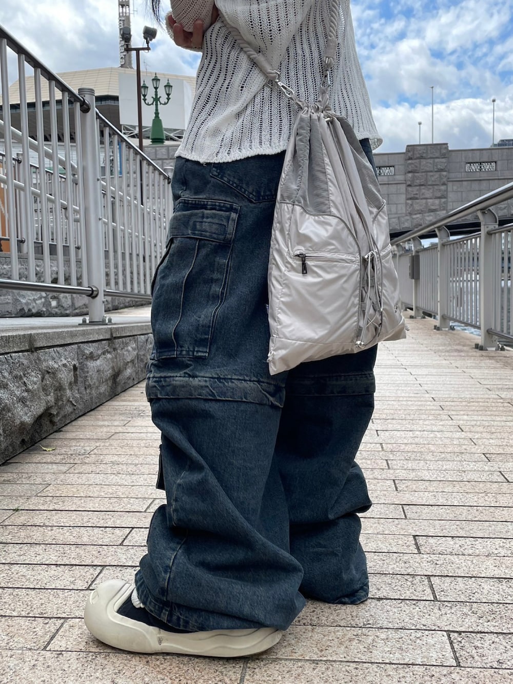 ブルー系のデニムパンツ、ブラック系のスニーカー、グレー系のバックパック/リュックを着用したレディースの春コーディネートの5枚目の写真