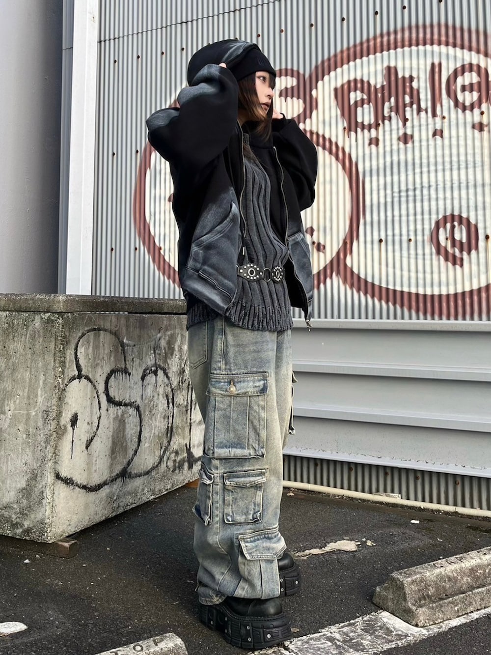 ブルー系のデニムパンツ、ブラック系のニット/セーター、ブラック系のパーカーを着用したレディースの秋コーディネートの2枚目の写真