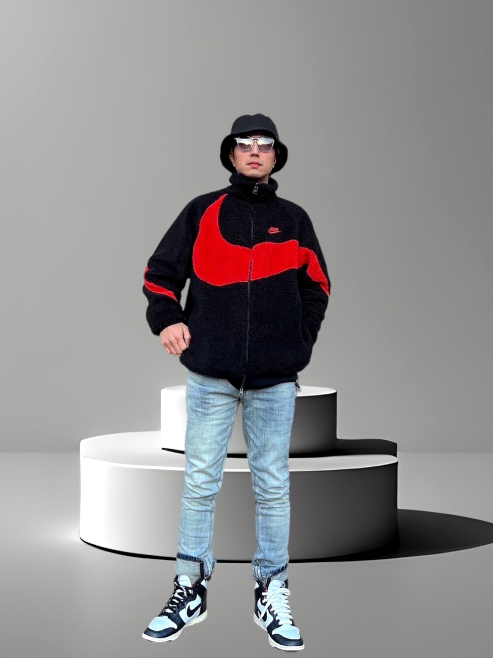 レッド系のブルゾン、ブルー系のデニムパンツ、ブラック系のスニーカーを着用したメンズの冬コーディネートの2枚目の写真