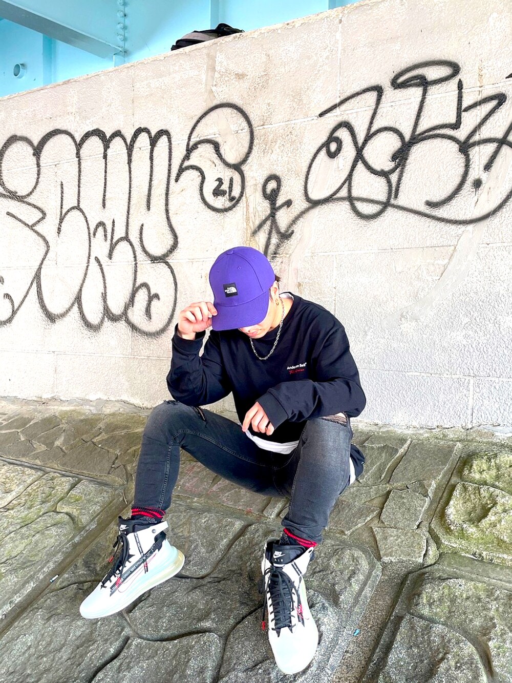 ブラック系のTシャツ/カットソー、ホワイト系のスニーカー、パープル系のキャップを着用したメンズの春コーディネートの2枚目の写真