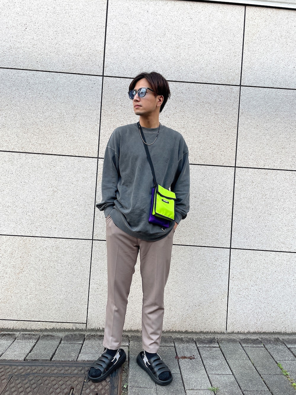 ブラック系のサンダル、グリーン系のショルダーバッグを着用したメンズの春コーディネートの2枚目の写真