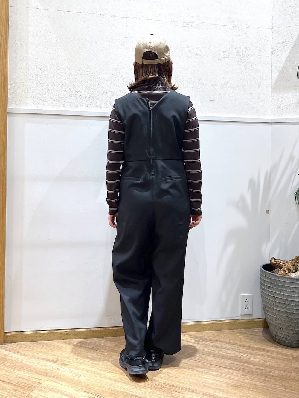 ブラウン系のニット/セーター、ブラック系のサロペット/オーバーオールを着用したレディースの冬コーディネートの3枚目の写真