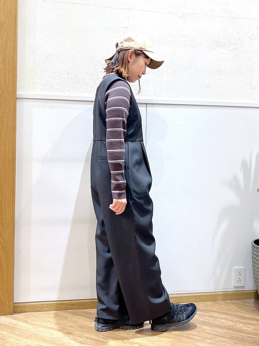 ブラウン系のニット/セーター、ブラック系のサロペット/オーバーオールを着用したレディースの冬コーディネートの4枚目の写真