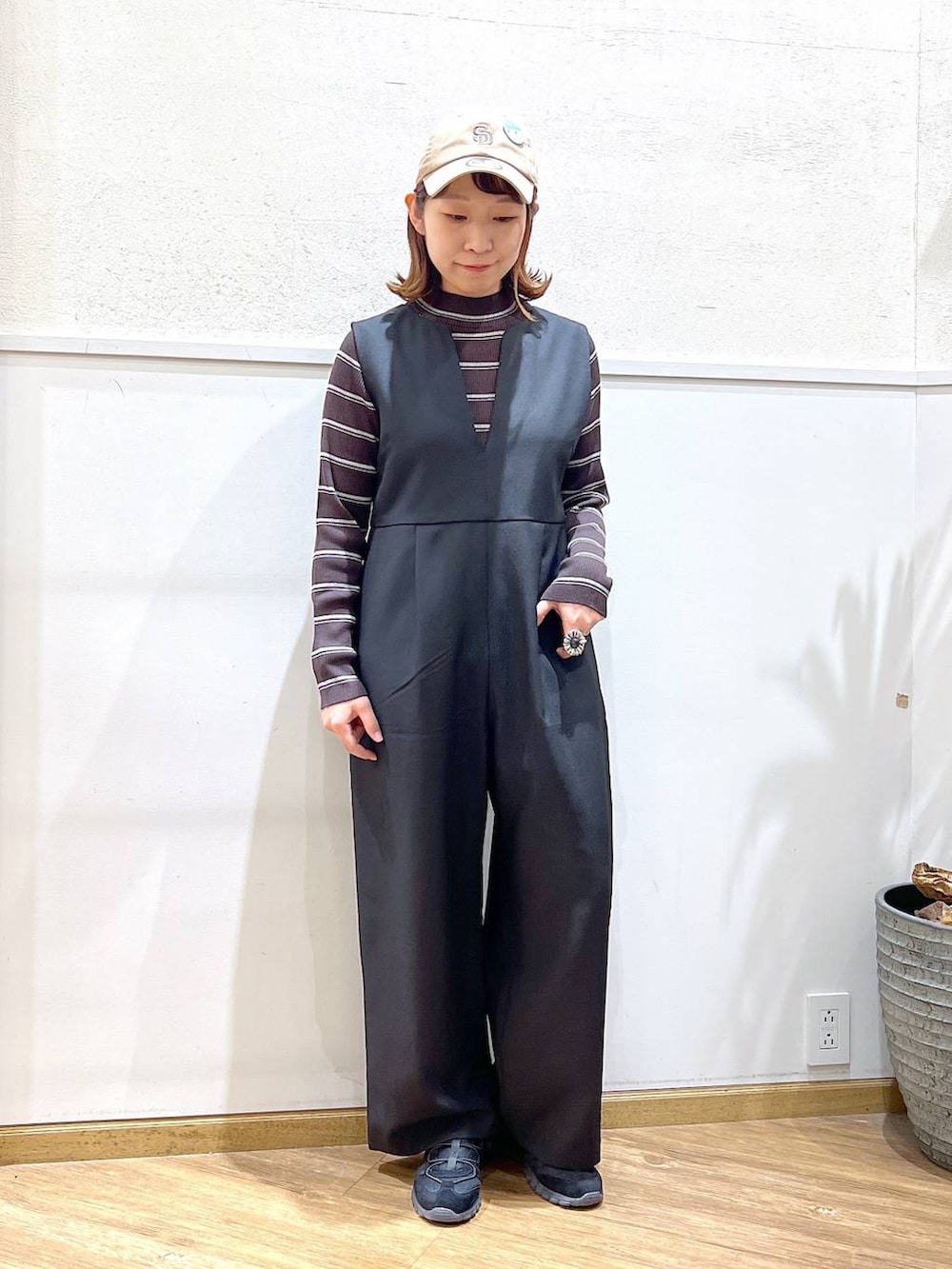 ブラウン系のニット/セーター、ブラック系のサロペット/オーバーオールを着用したレディースの冬コーディネートの5枚目の写真