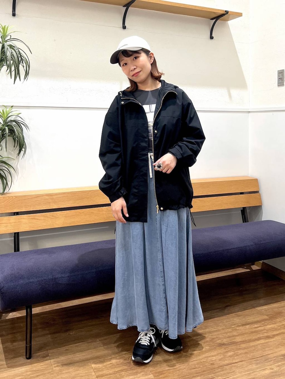 ブラック系のマウンテンパーカー、グレー系のTシャツ/カットソー、ブルー系のデニムスカートを着用したレディースの春コーディネートの5枚目の写真