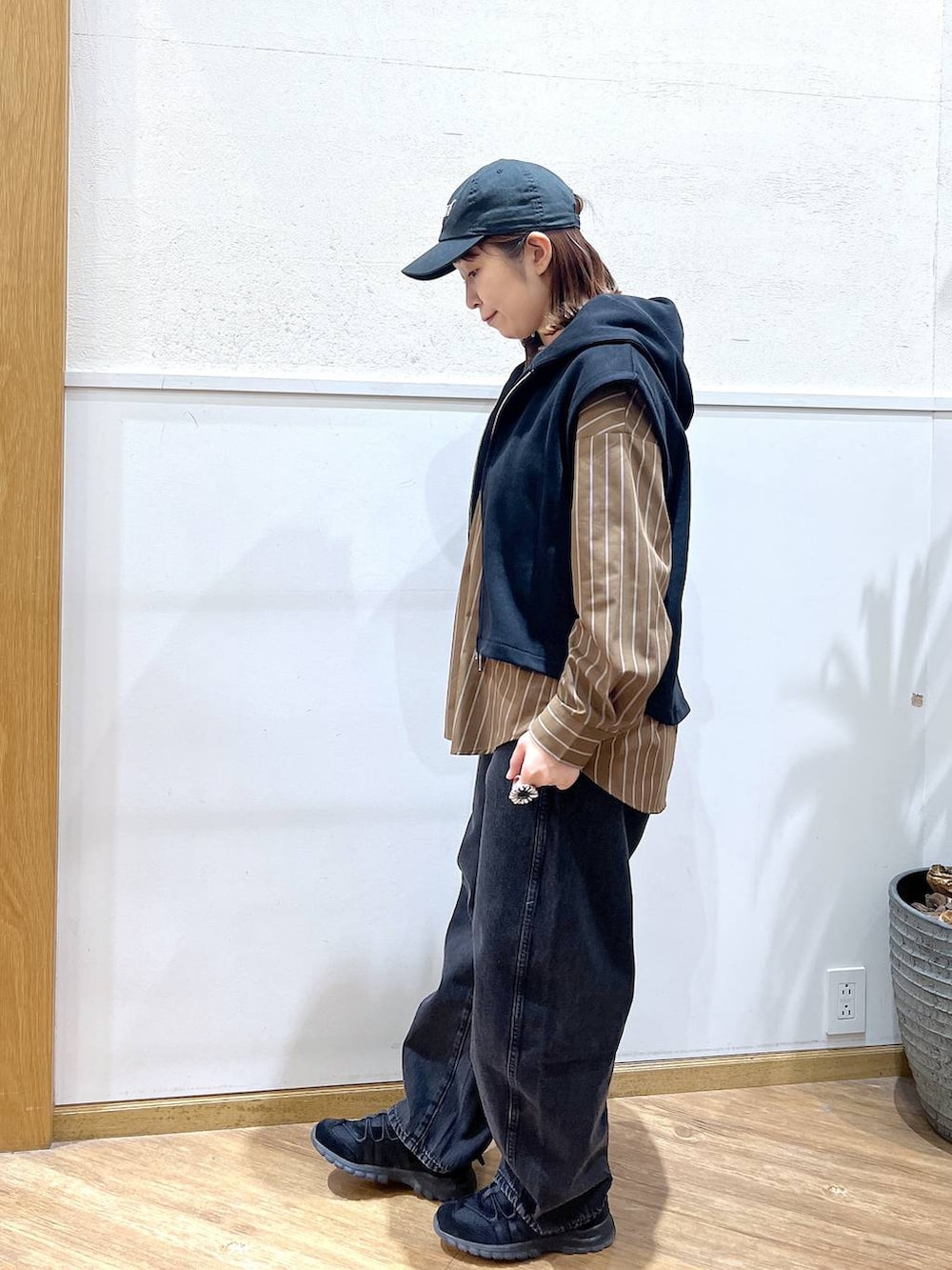 ブラウン系のシャツ/ブラウス、ブラック系のデニムパンツ、ブラック系のベストを着用したレディースの春コーディネートの4枚目の写真