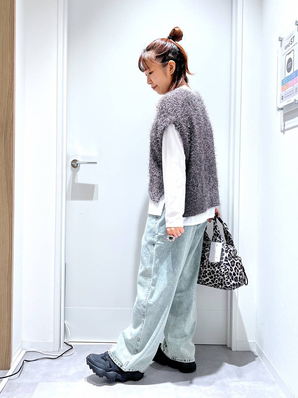 その他のトートバッグ、ブルー系のデニムパンツ、グレー系のベストを着用したレディースの秋コーディネートの4枚目の写真