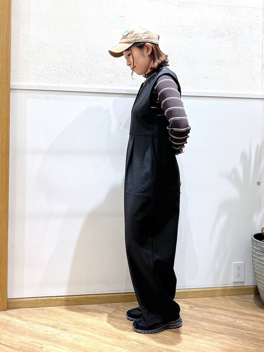 ブラウン系のニット/セーター、ブラック系のサロペット/オーバーオールを着用したレディースの冬コーディネートの2枚目の写真