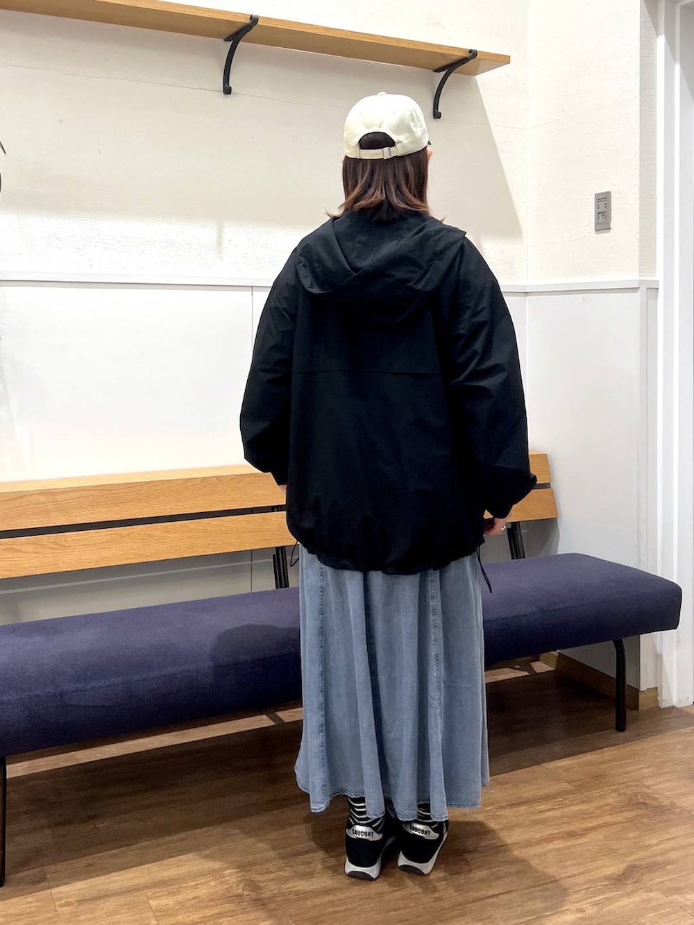 ブラック系のマウンテンパーカー、グレー系のTシャツ/カットソー、ブルー系のデニムスカートを着用したレディースの春コーディネートの3枚目の写真