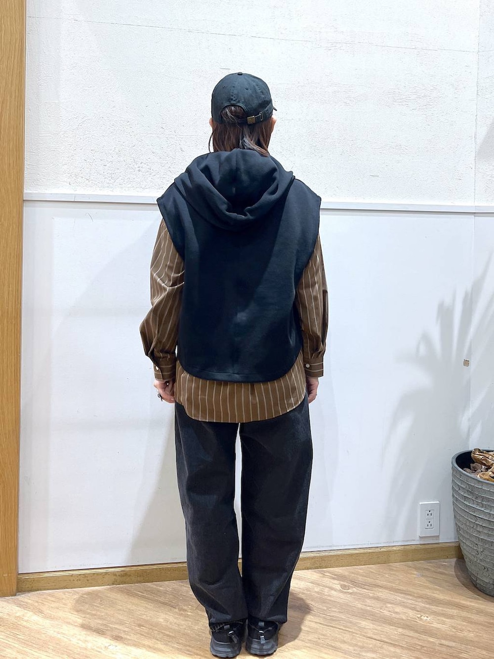 ブラウン系のシャツ/ブラウス、ブラック系のデニムパンツ、ブラック系のベストを着用したレディースの春コーディネートの3枚目の写真