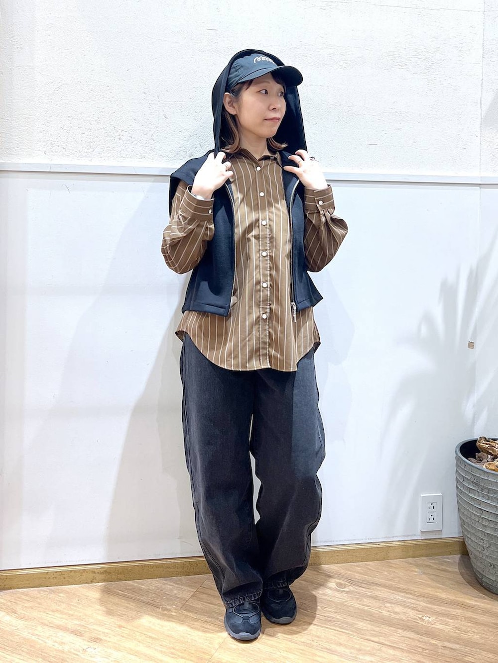 ブラウン系のシャツ/ブラウス、ブラック系のデニムパンツ、ブラック系のベストを着用したレディースの春コーディネートの5枚目の写真