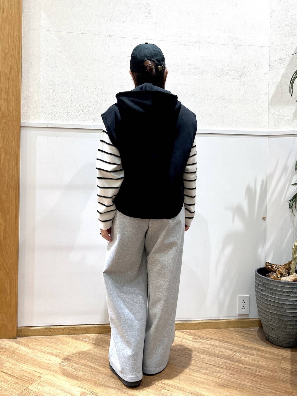 ホワイト系のニット/セーター、グレー系のスウェットパンツ、ブラック系のベストを着用したレディースの冬コーディネートの3枚目の写真