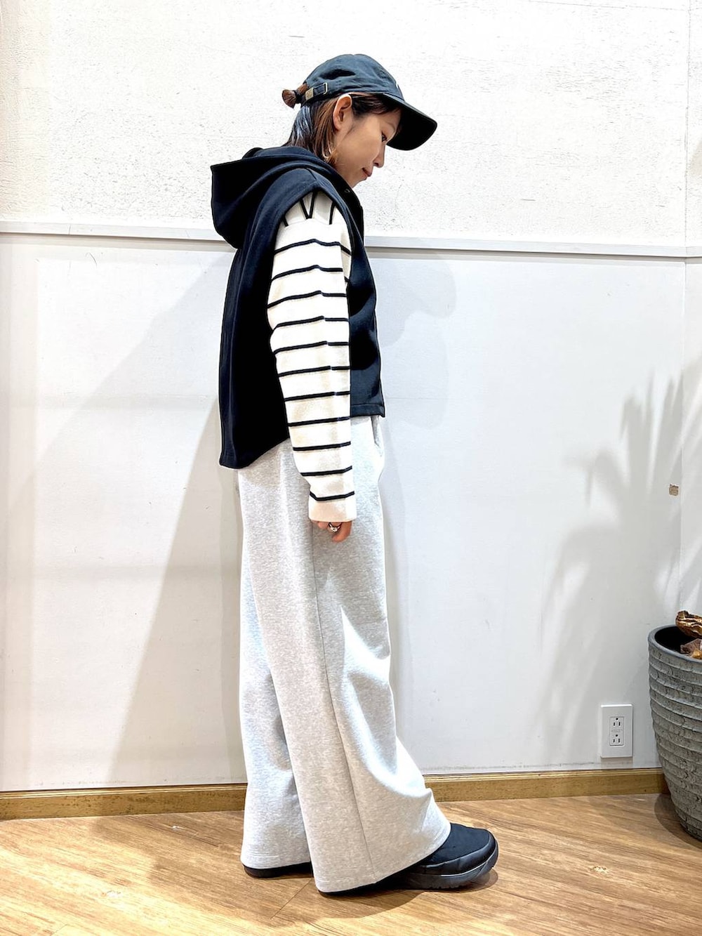 ホワイト系のニット/セーター、グレー系のスウェットパンツ、ブラック系のベストを着用したレディースの冬コーディネートの2枚目の写真