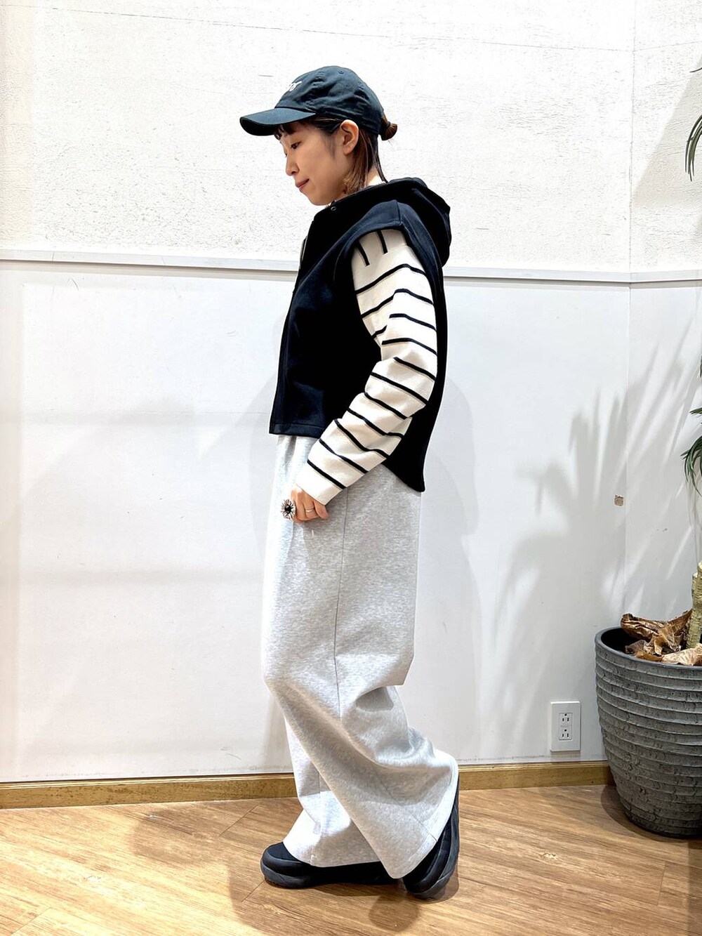 ホワイト系のニット/セーター、グレー系のスウェットパンツ、ブラック系のベストを着用したレディースの冬コーディネートの4枚目の写真