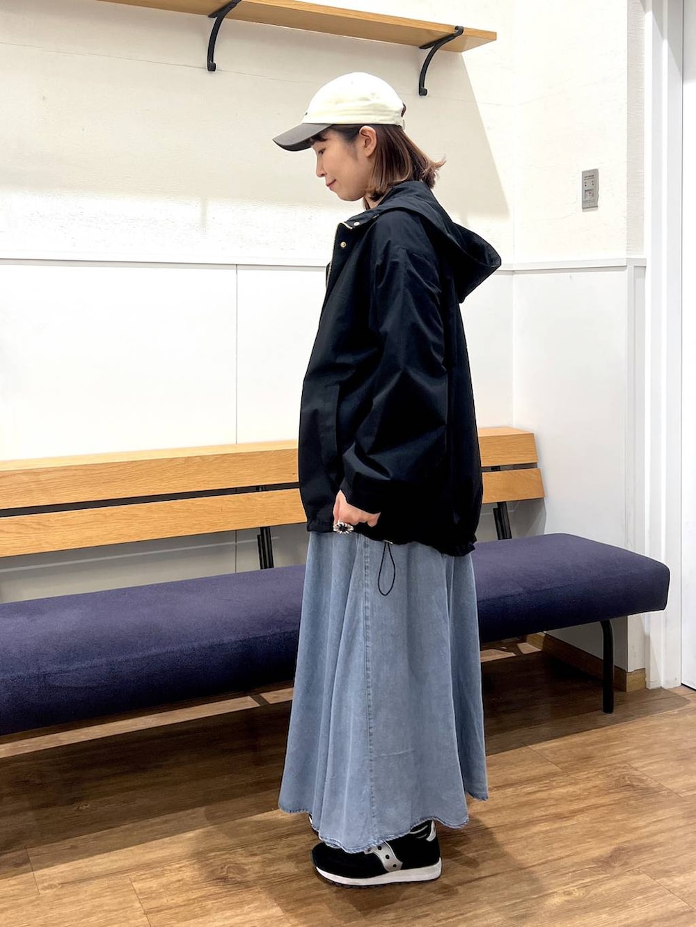 ブラック系のマウンテンパーカー、グレー系のTシャツ/カットソー、ブルー系のデニムスカートを着用したレディースの春コーディネートの2枚目の写真