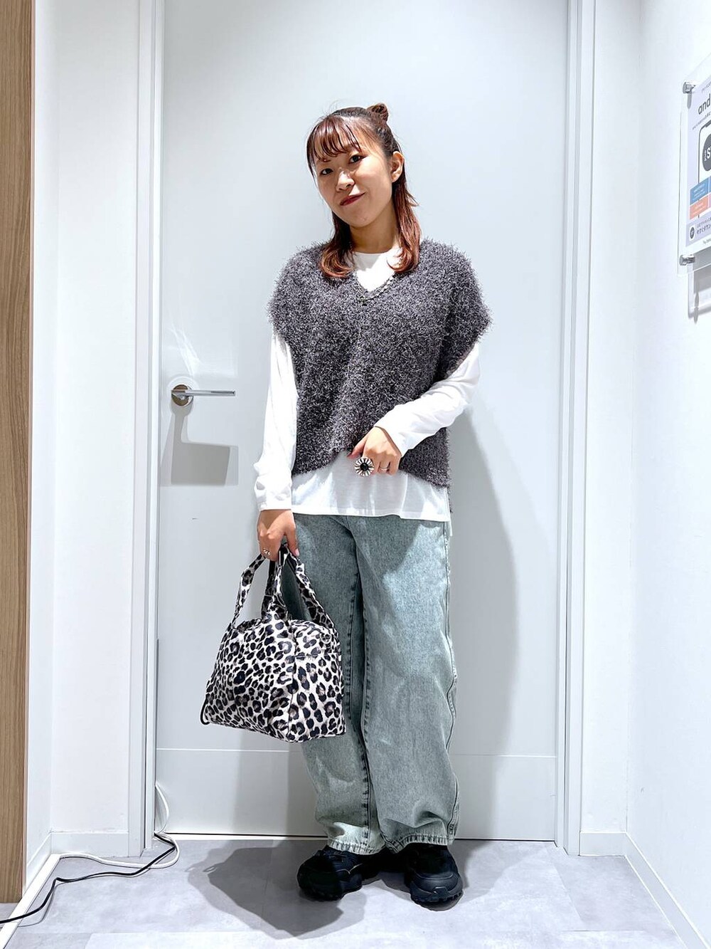 その他のトートバッグ、ブルー系のデニムパンツ、グレー系のベストを着用したレディースの秋コーディネートの5枚目の写真