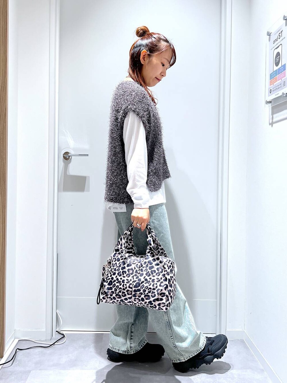 その他のトートバッグ、ブルー系のデニムパンツ、グレー系のベストを着用したレディースの秋コーディネートの2枚目の写真