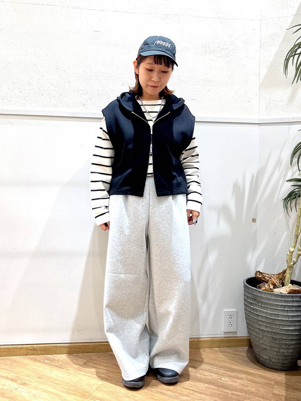 ホワイト系のニット/セーター、グレー系のスウェットパンツ、ブラック系のベストを着用したレディースの冬コーディネートの5枚目の写真