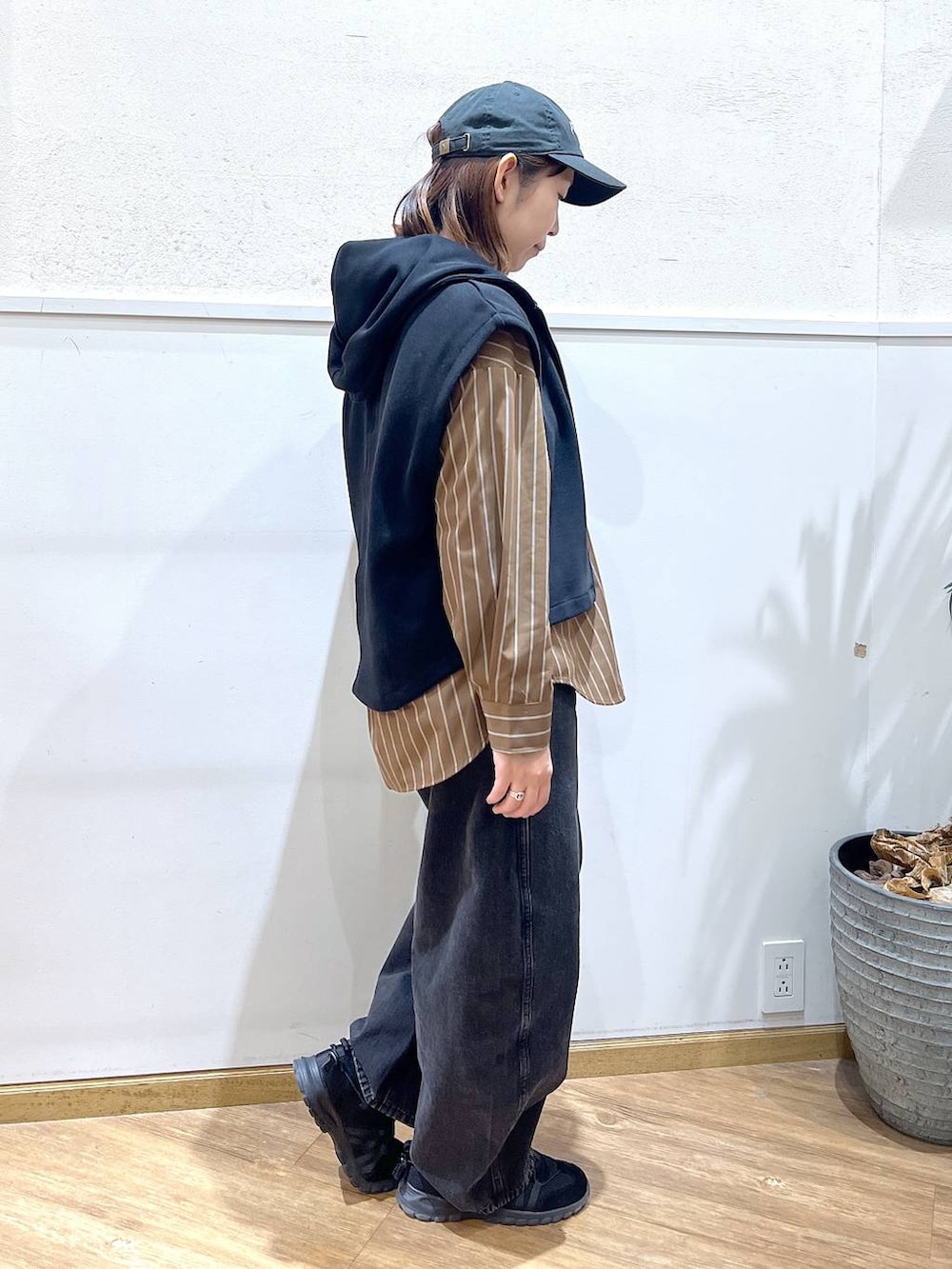 ブラウン系のシャツ/ブラウス、ブラック系のデニムパンツ、ブラック系のベストを着用したレディースの春コーディネートの2枚目の写真