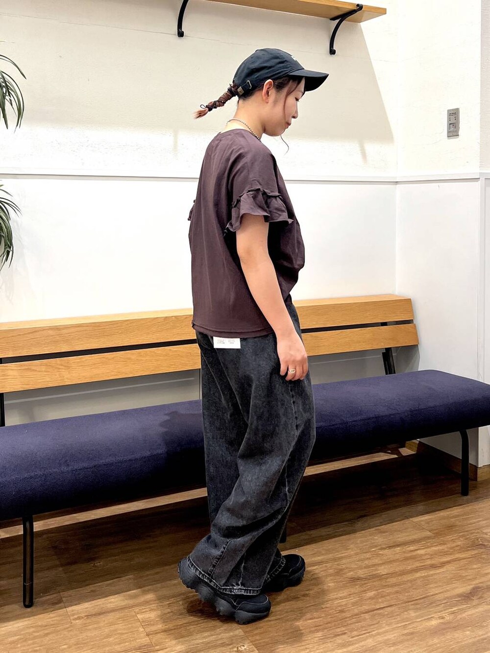 ブラック系のデニムパンツ、ブラウン系のTシャツ/カットソーを着用したレディースの春コーディネートの2枚目の写真