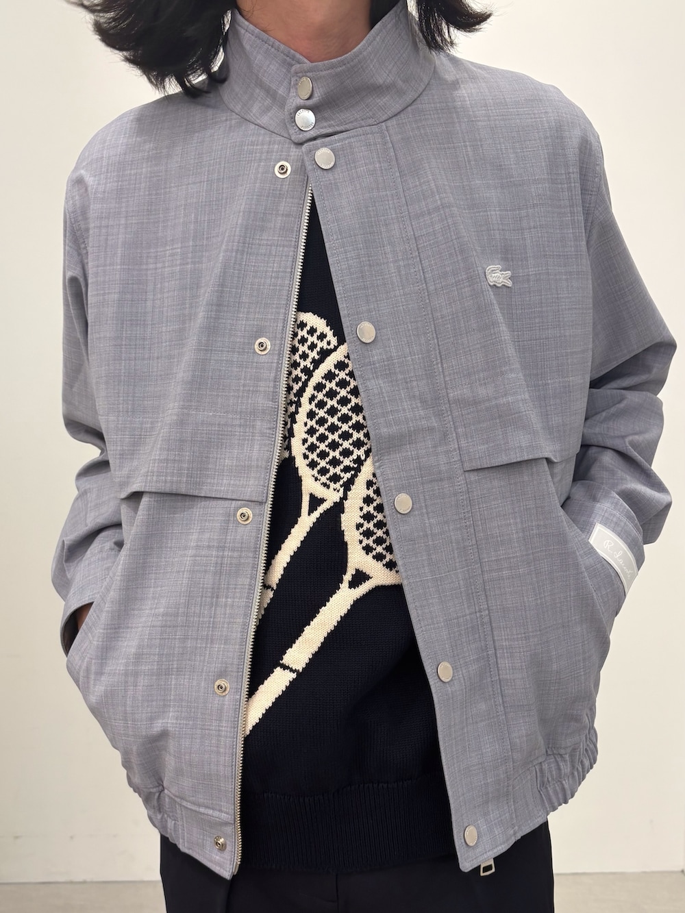 ブラック系のベスト、ブルー系のスラックス、ブラック系のスニーカーを着用したメンズの春コーディネートの3枚目の写真