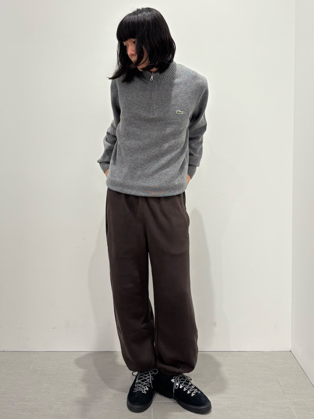 ブルー系のダウンジャケット/コート、グレー系のニット/セーター、ブラウン系のスウェットパンツを着用したメンズの秋コーディネートの3枚目の写真