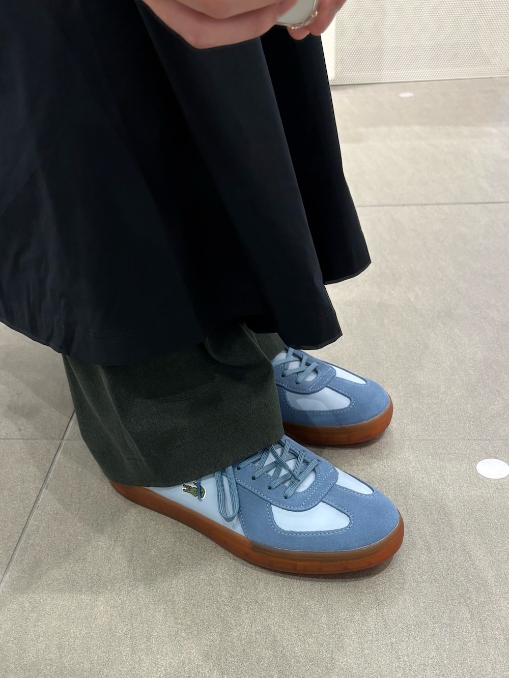 ブルー系のポロシャツ、グレー系のその他パンツ、ブルー系のスカートを着用したメンズの春コーディネートの6枚目の写真