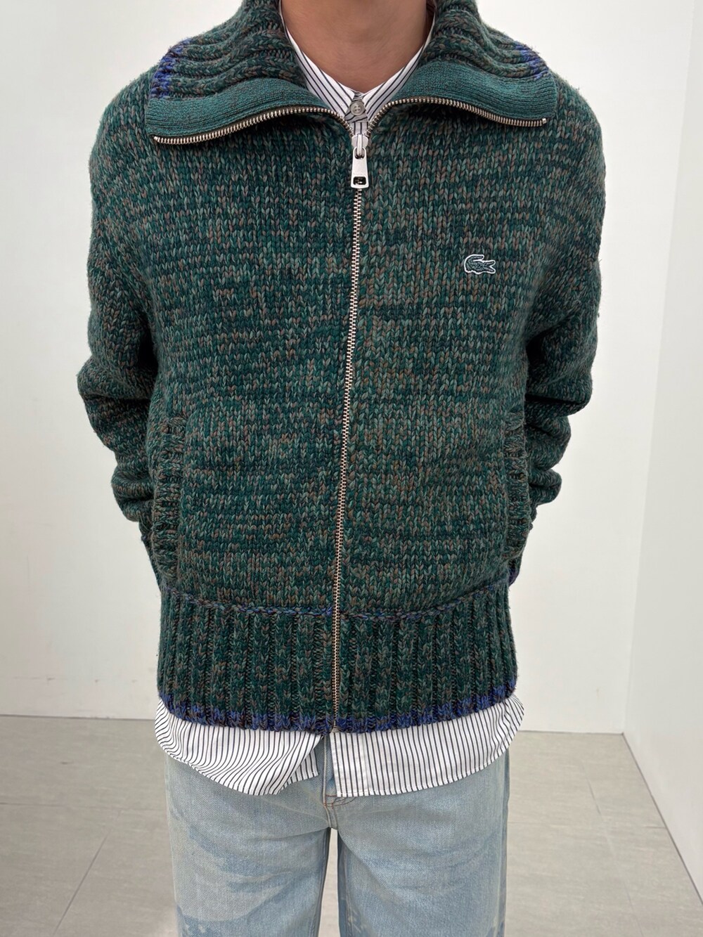 ブラウン系のブルゾン、ホワイト系のシャツ/ブラウス、グリーン系のニット/セーターを着用したメンズの冬コーディネートの6枚目の写真