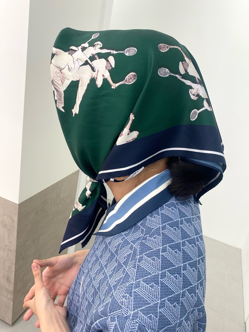 ブルー系のポロシャツ、ホワイト系のスニーカー、ブルー系のトートバッグを着用したメンズの春コーディネートの6枚目の写真