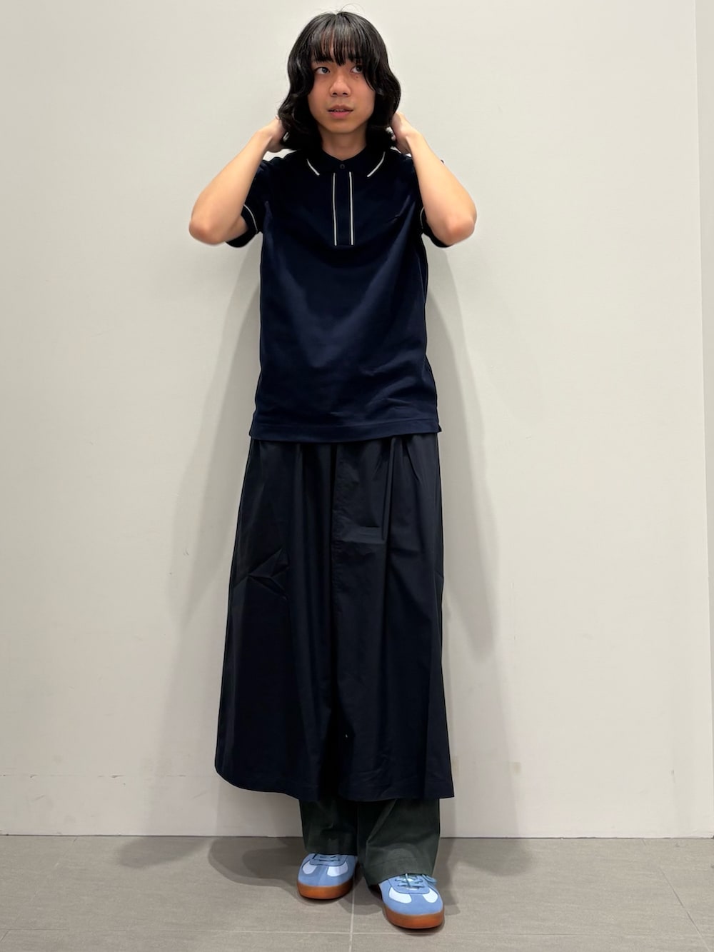 ブルー系のポロシャツ、グレー系のその他パンツ、ブルー系のスカートを着用したメンズの春コーディネートの3枚目の写真