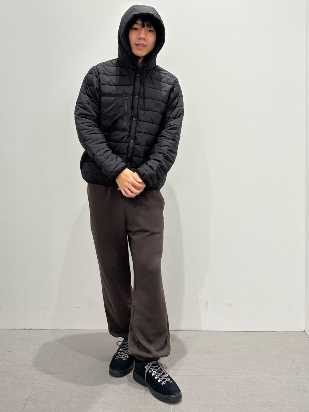 ブルー系のダウンジャケット/コート、グレー系のニット/セーター、ブラウン系のスウェットパンツを着用したメンズの秋コーディネートの6枚目の写真