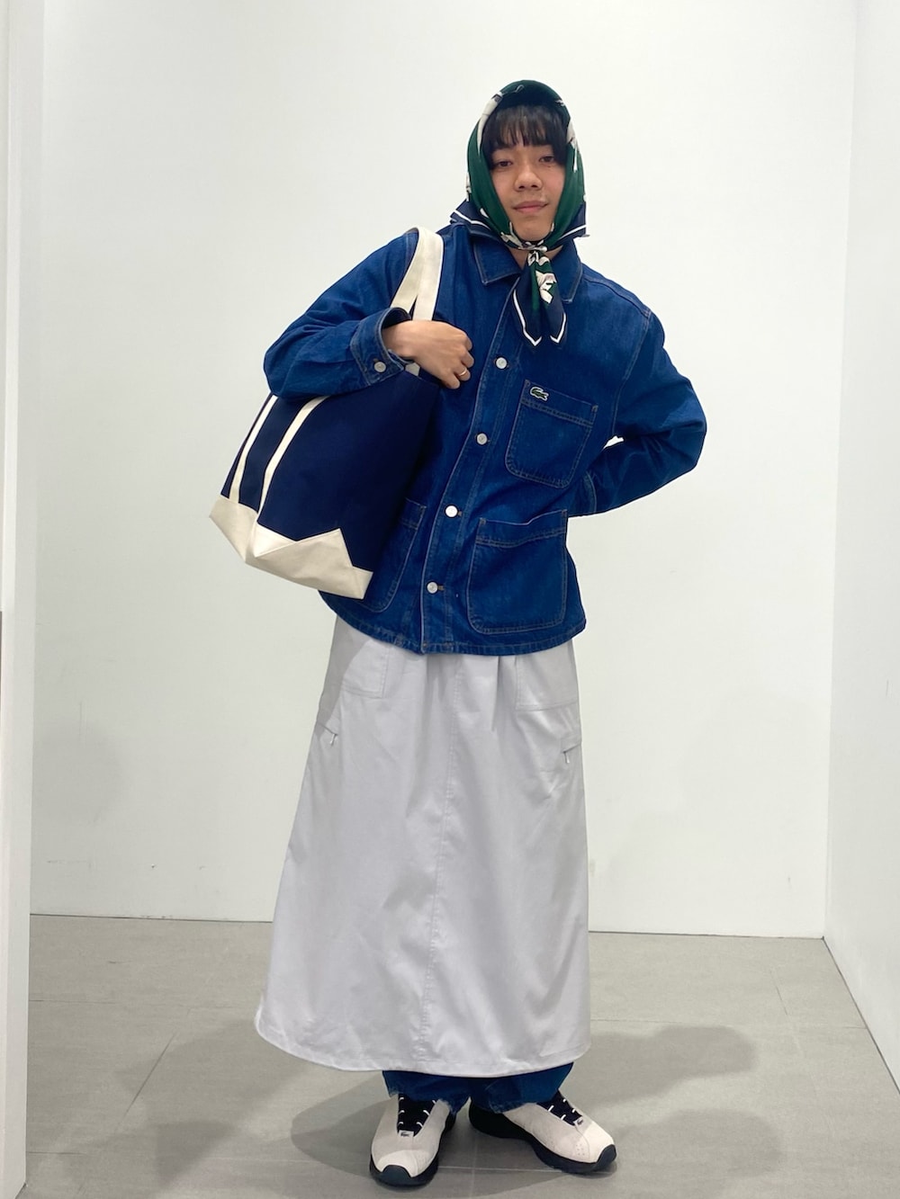 ブルー系のポロシャツ、ホワイト系のスニーカー、ブルー系のトートバッグを着用したメンズの春コーディネートの3枚目の写真