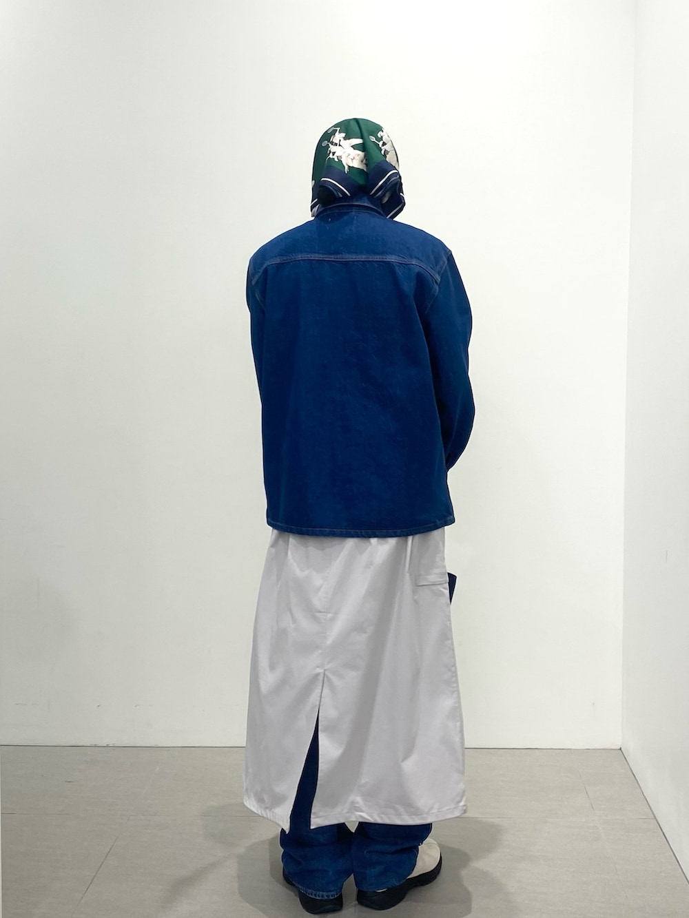 ブルー系のポロシャツ、ホワイト系のスニーカー、ブルー系のトートバッグを着用したメンズの春コーディネートの5枚目の写真