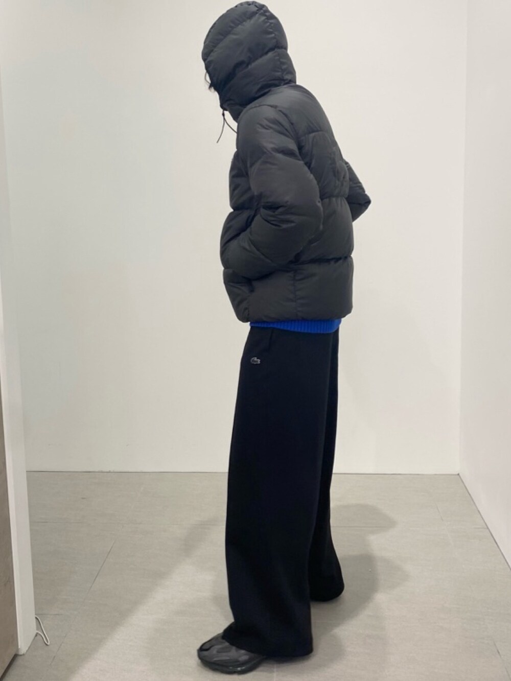 ブラック系のダウンジャケット/コート、ブルー系のニット/セーター、ブラック系のその他パンツを着用したメンズの夏コーディネートの5枚目の写真