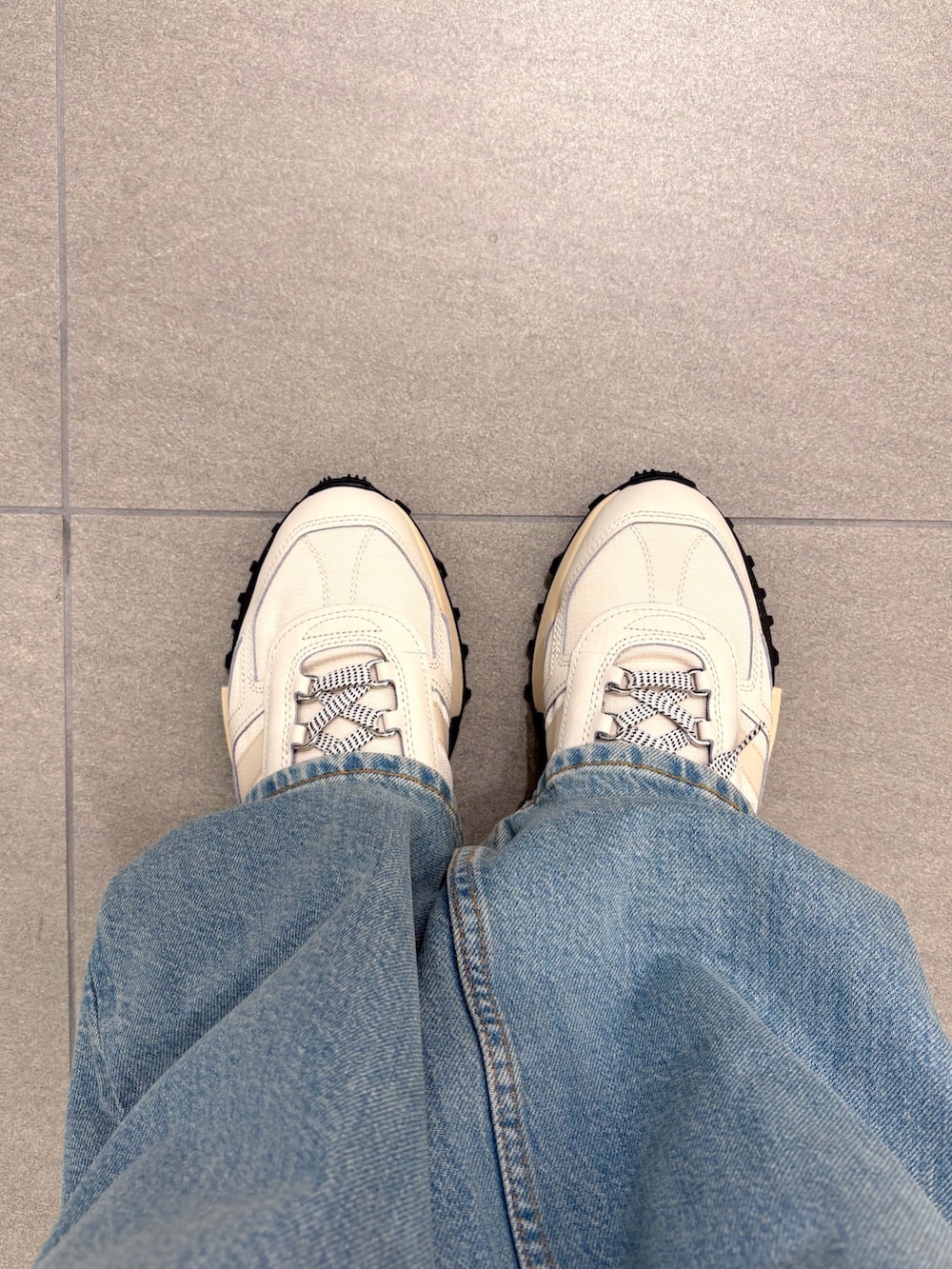 ブラック系のダウンジャケット/コート、イエロー系のシャツ/ブラウス、ブルー系のデニムパンツを着用したメンズの秋コーディネートの8枚目の写真