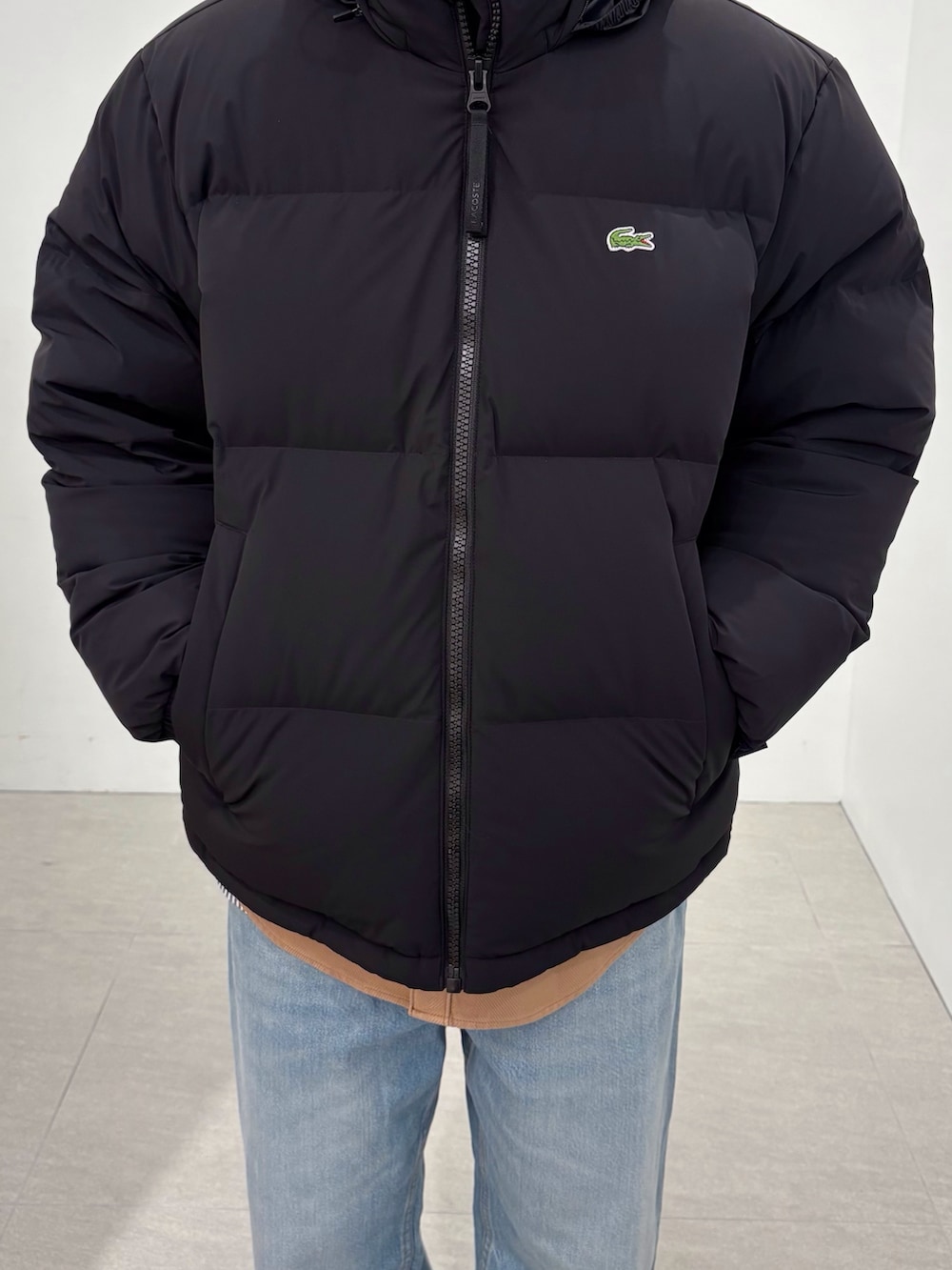 ブラック系のダウンジャケット/コート、イエロー系のシャツ/ブラウス、ブルー系のデニムパンツを着用したメンズの秋コーディネートの6枚目の写真