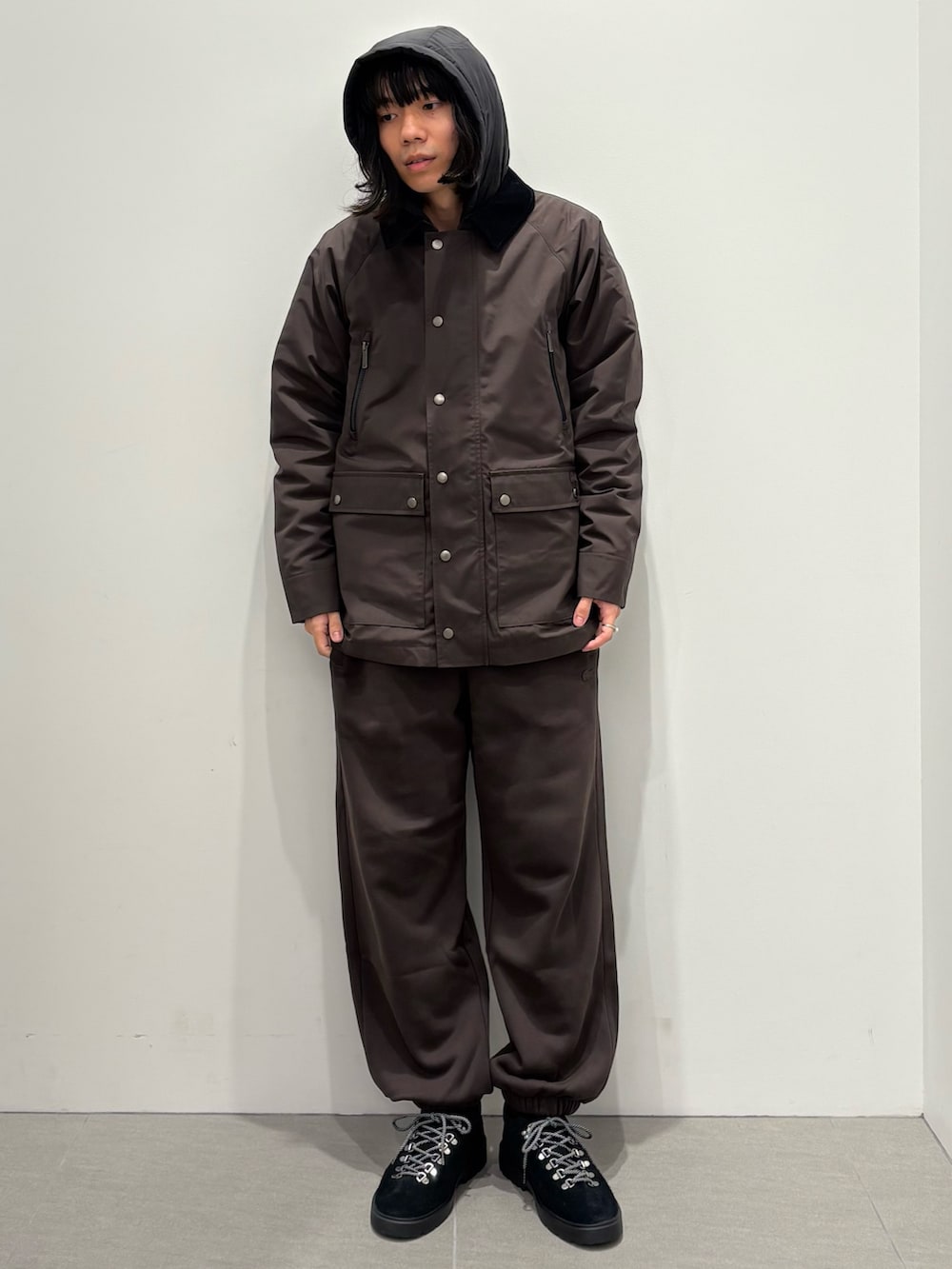 ブルー系のダウンジャケット/コート、グレー系のニット/セーター、ブラウン系のスウェットパンツを着用したメンズの秋コーディネートの4枚目の写真