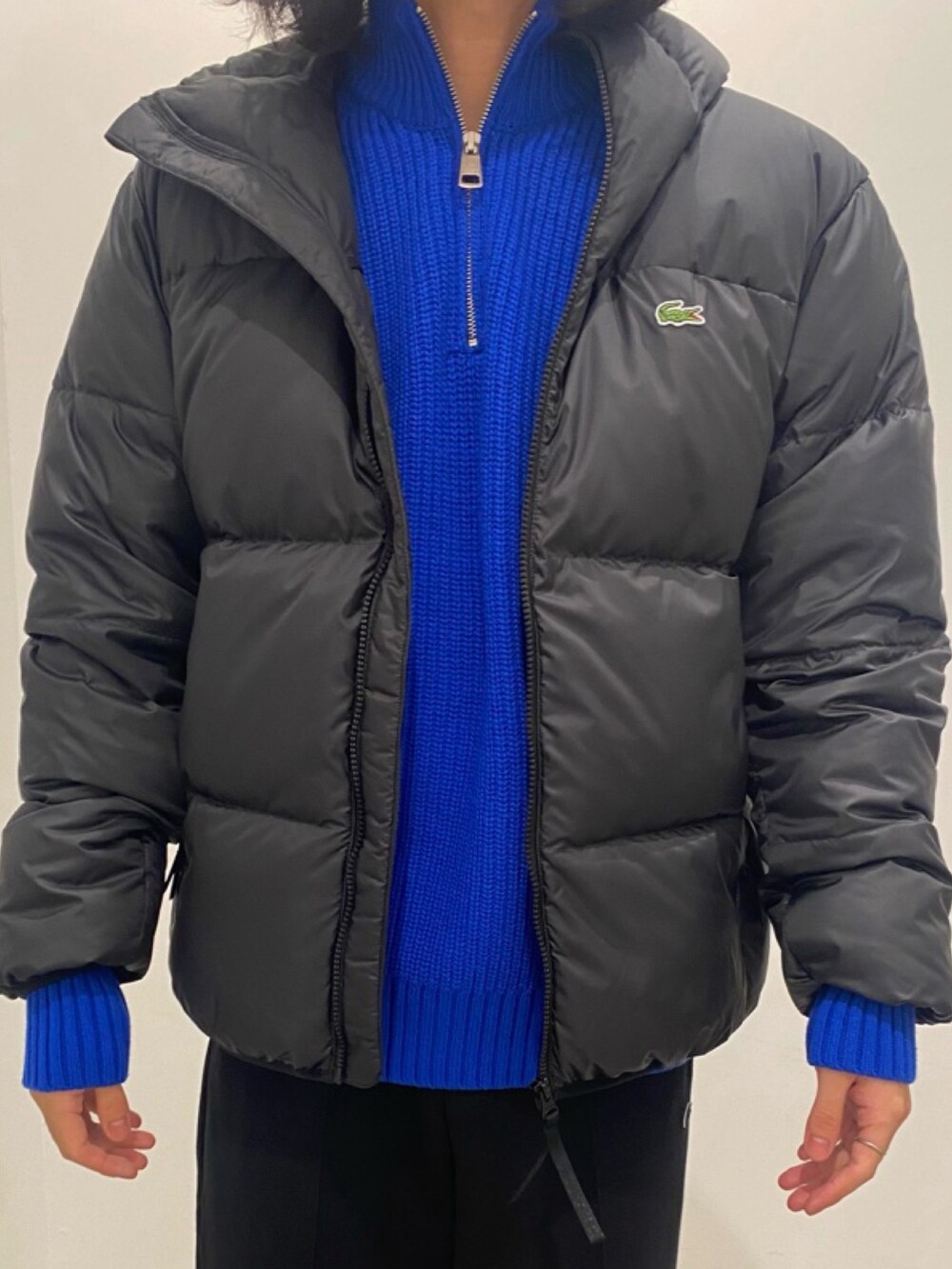 ブラック系のダウンジャケット/コート、ブルー系のニット/セーター、ブラック系のその他パンツを着用したメンズの夏コーディネートの2枚目の写真