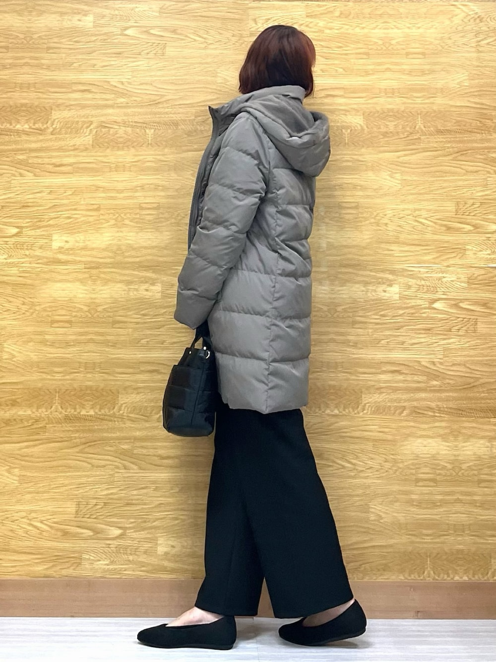 グリーン系のダウンジャケット/コート、レッド系のニット/セーター、ブラック系のトートバッグを着用したレディースの冬コーディネートの2枚目の写真