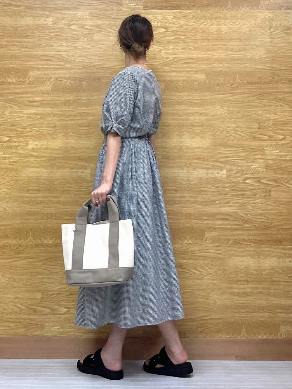 ブラック系のサンダル、ブラック系のスカート、ベージュ系のトートバッグを着用したレディースの春コーディネートの2枚目の写真