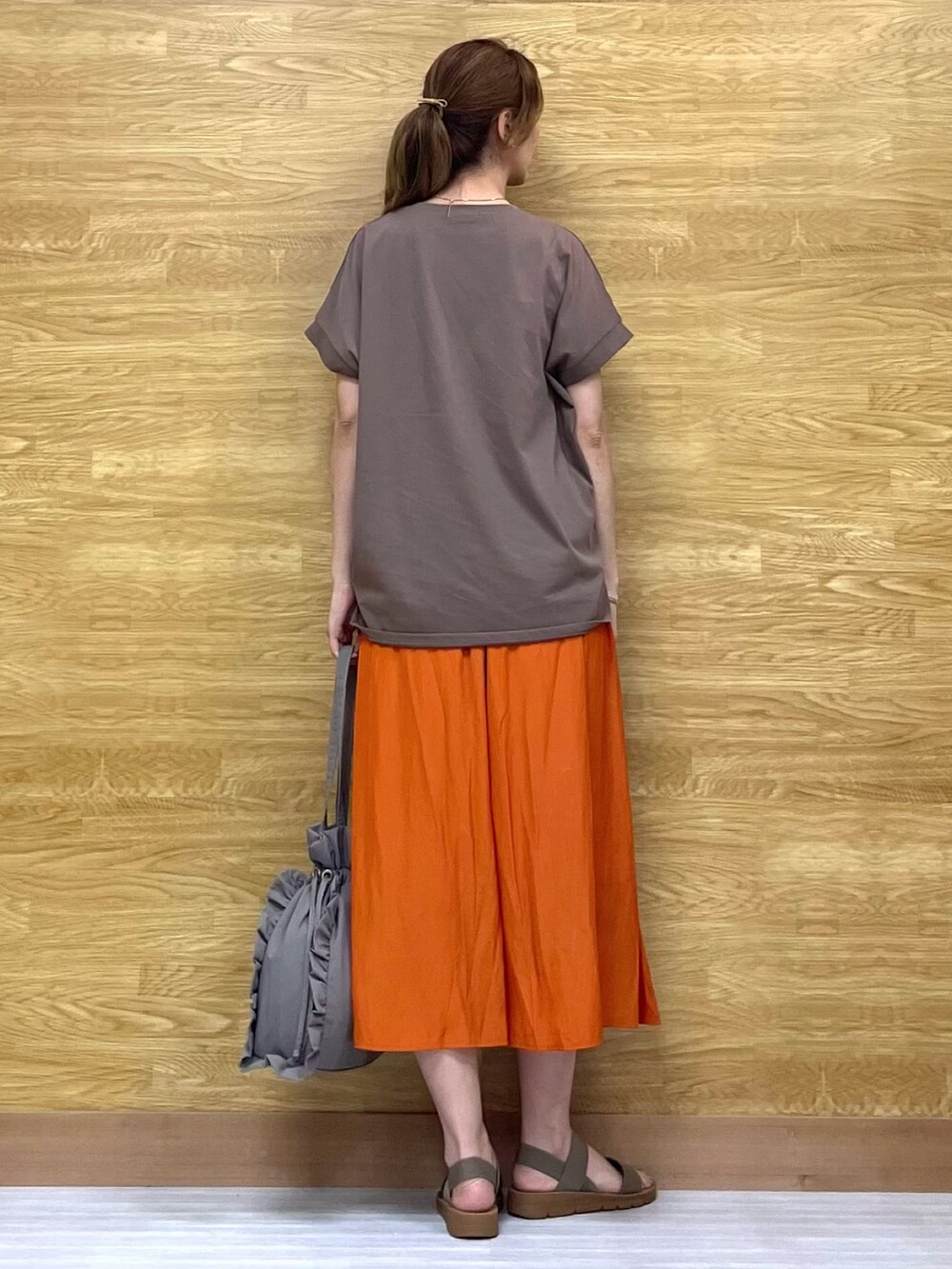 オレンジ系のその他パンツ、グレー系のトートバッグ、ベージュ系のサンダルを着用したレディースの夏コーディネートの3枚目の写真