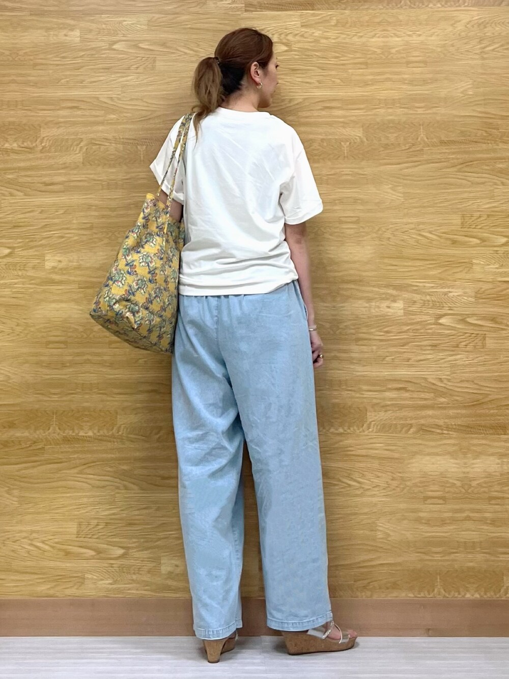 ホワイト系のTシャツ/カットソー、シルバー系のサンダル、イエロー系のトートバッグを着用したレディースの夏コーディネートの3枚目の写真