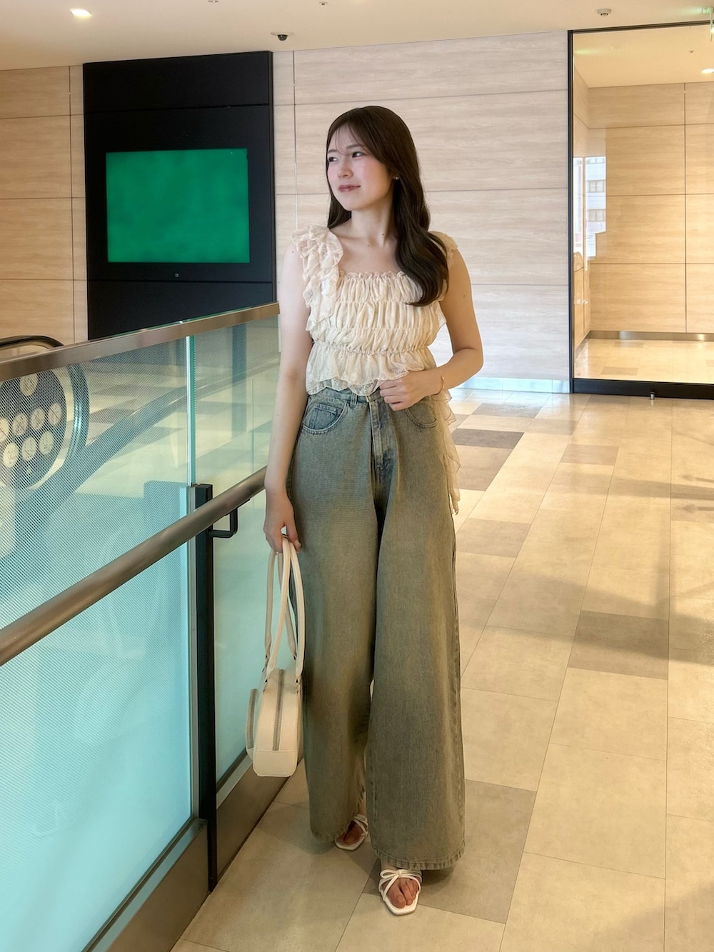 ピンク系のシャツ/ブラウス、ブルー系のデニムパンツ、ホワイト系のボストンバッグを着用したレディースの春コーディネートの2枚目の写真