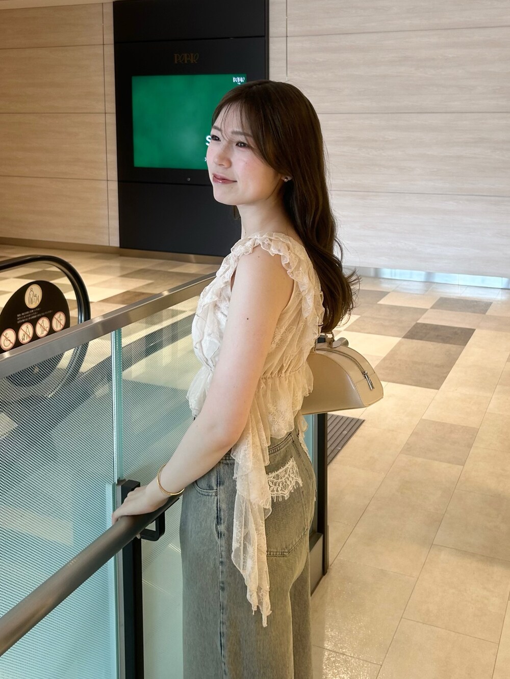 ピンク系のシャツ/ブラウス、ブルー系のデニムパンツ、ホワイト系のボストンバッグを着用したレディースの春コーディネートの4枚目の写真