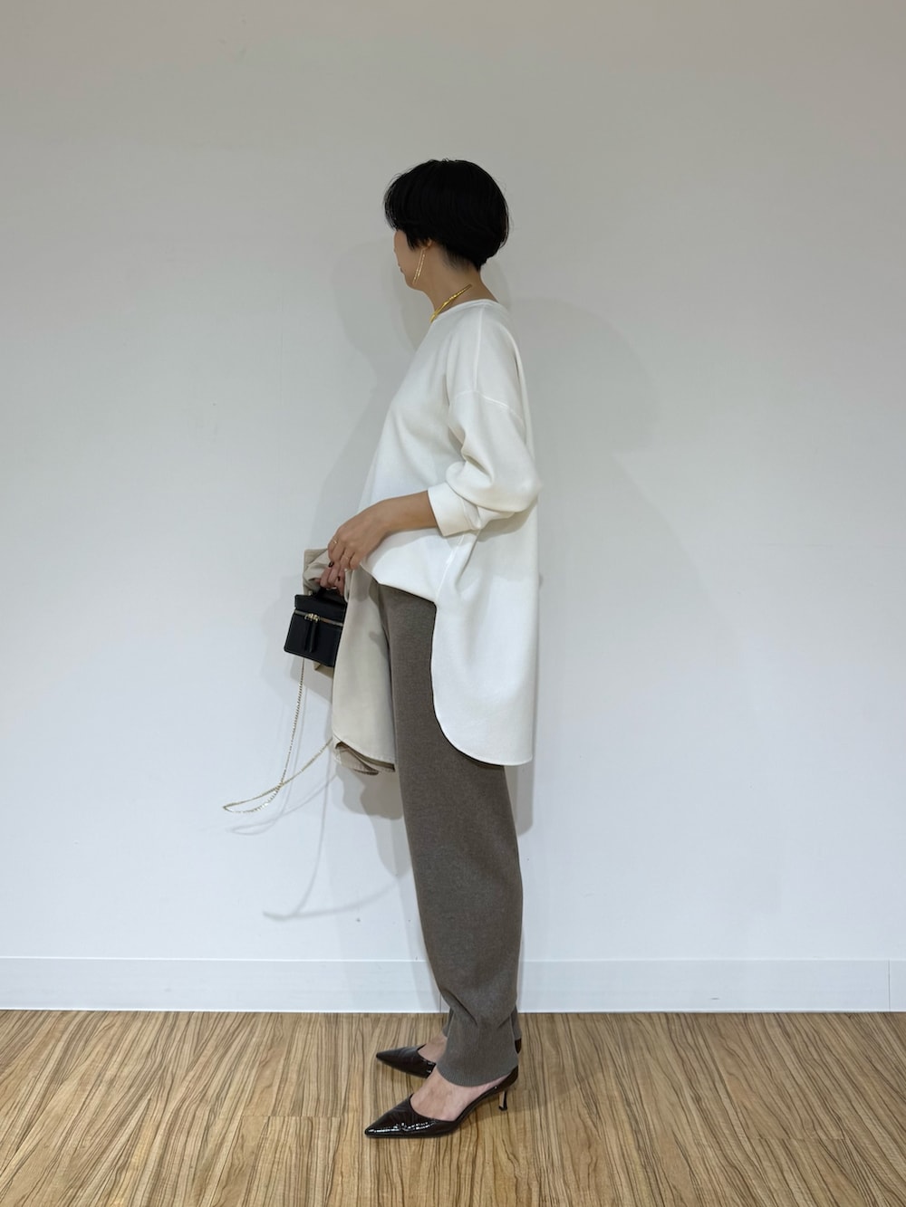 ホワイト系のシャツ/ブラウス、ベージュ系のシャツ/ブラウス、ブラック系のショルダーバッグを着用したレディースの秋コーディネートの2枚目の写真