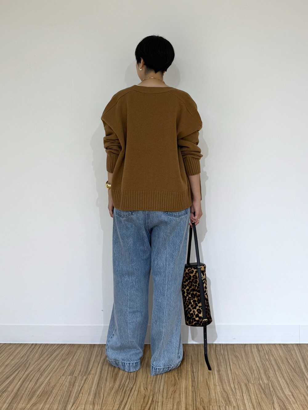 ブルー系のデニムパンツ、イエロー系のショルダーバッグ、ホワイト系のシャツ/ブラウスを着用したレディースの秋コーディネートの3枚目の写真