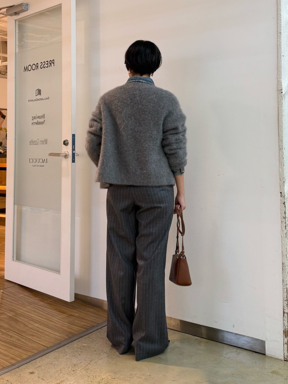 グレー系のカーディガン/ボレロ、ブルー系のデニムジャケット、ブラウン系のパンプスを着用したレディースの秋コーディネートの3枚目の写真