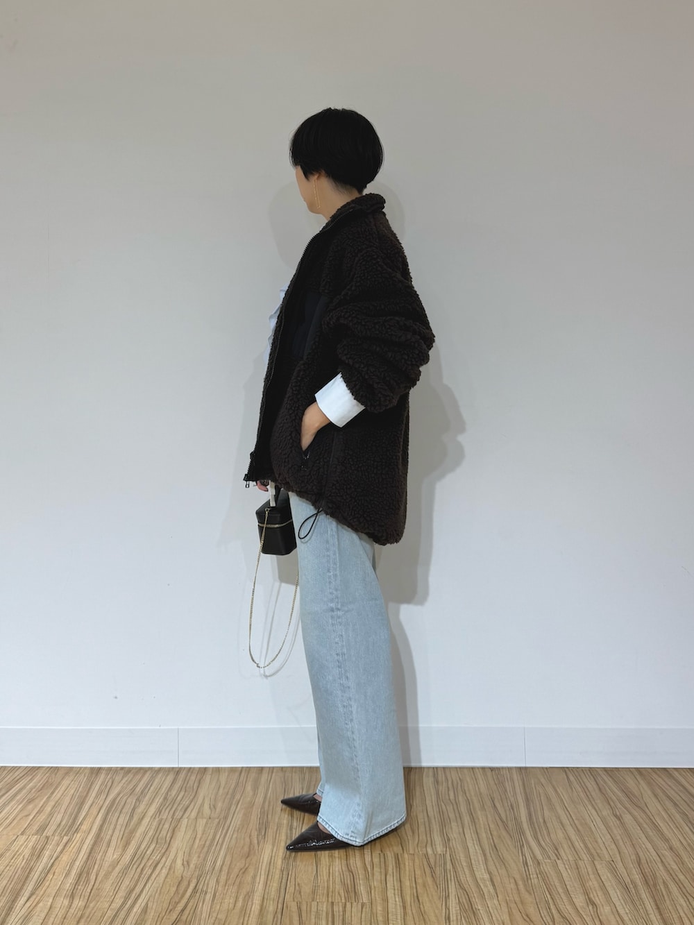 ブルー系のシャツ/ブラウス、ブラウン系のその他アウター、ブルー系のデニムパンツを着用したレディースの秋コーディネートの2枚目の写真
