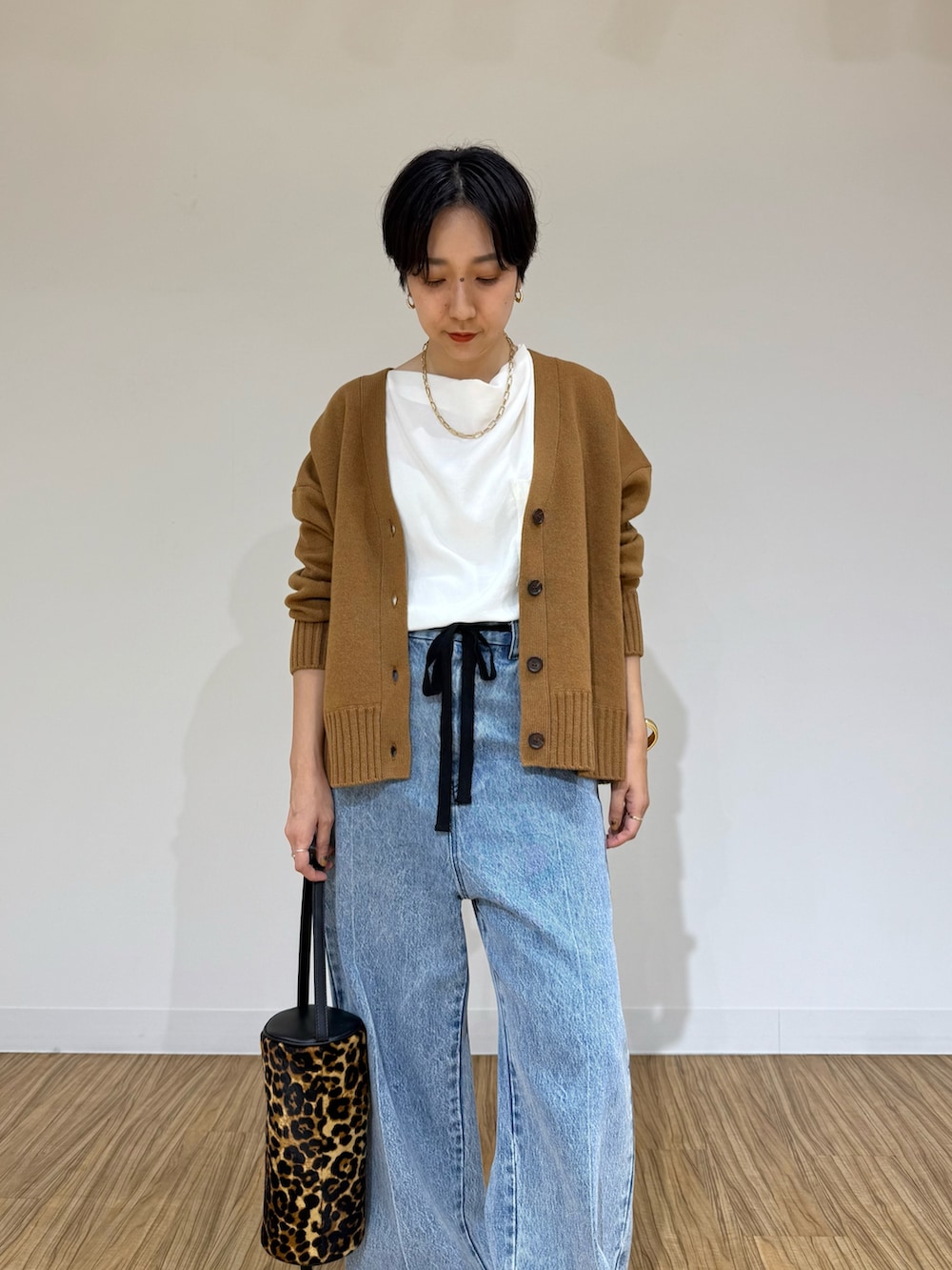 ブルー系のデニムパンツ、イエロー系のショルダーバッグ、ホワイト系のシャツ/ブラウスを着用したレディースの秋コーディネートの4枚目の写真